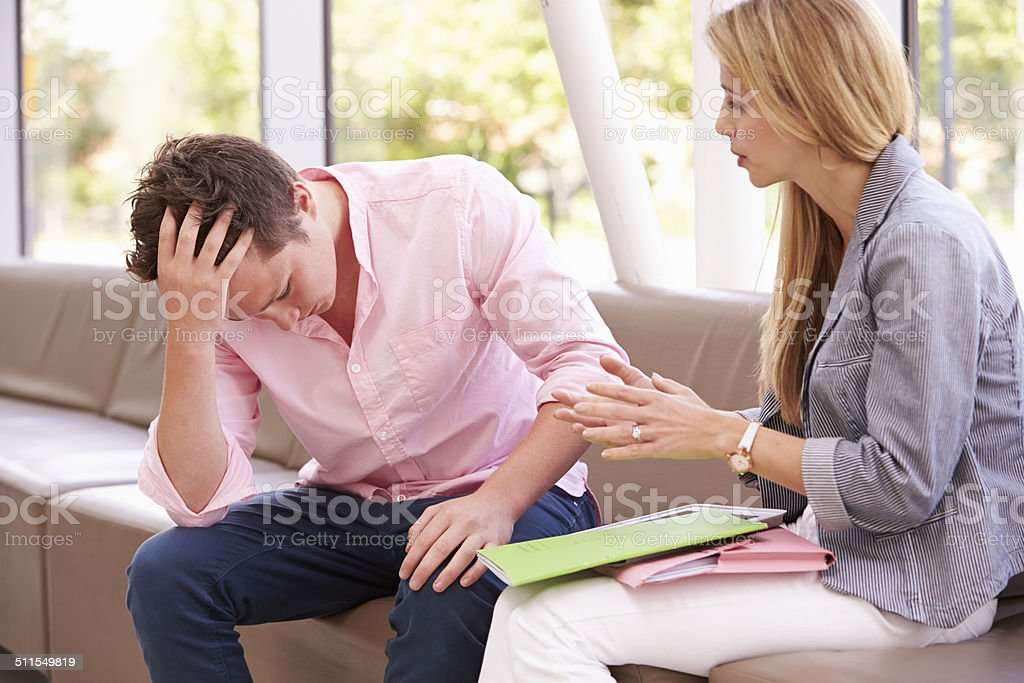Depressed College Student Talking To Counselor Stock Photo