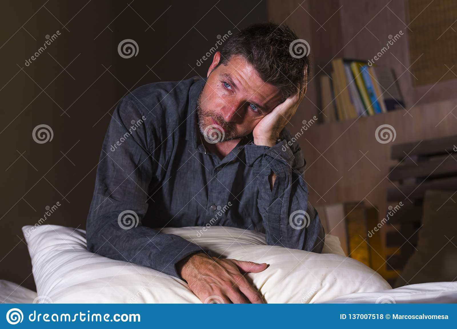 Young Attractive Sad And Depressed Man On Bed Suffering Anxiety Crisis ...